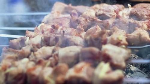 Barbecue-Fleisch, zubereitet auf Holzkohle. Schaschlik am Spieß rösten. Rauch geht durch Shashli...