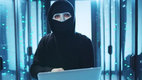 A Hacker Infiltrating a Data Center While Working on a Laptop Engaging in Illicit Activities