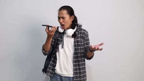 Young Man Arguing on Smartphone in Studio