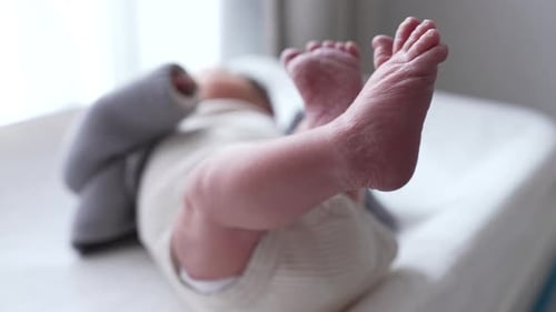 Tiny Baby Feet Kicking on Changing Table Indoors