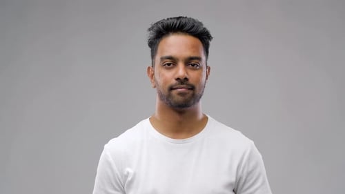 Smiling man gives an okay hand gesture