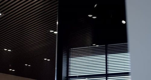 Plafonnier moderne rond noir dans un intérieur moderne avec des lignes en bois noires