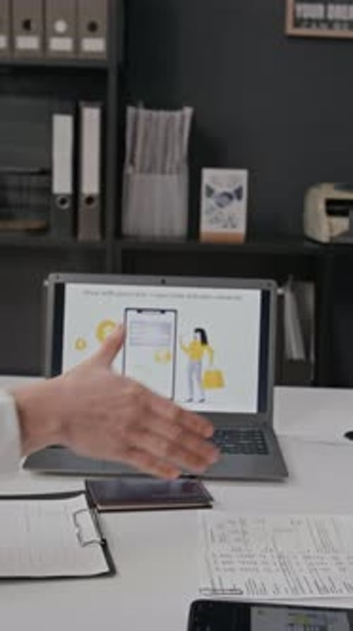Business Handshake Over Laptop with Charts and Data