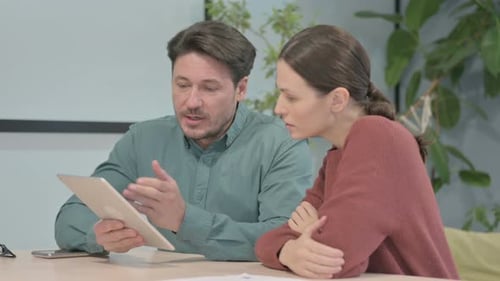 Colleagues Discussing Tablet Project Together Indoors