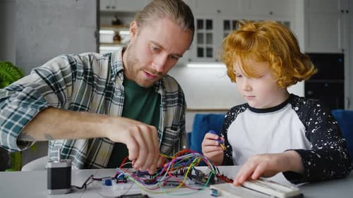 Father and Child Working with Electronic Circuits at Home