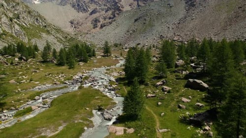 Mountain River flowing through a Valley in the Italian Alps from a Drone, very High View