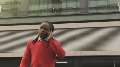 Man in Red Sweater Talking on Phone Outdoors