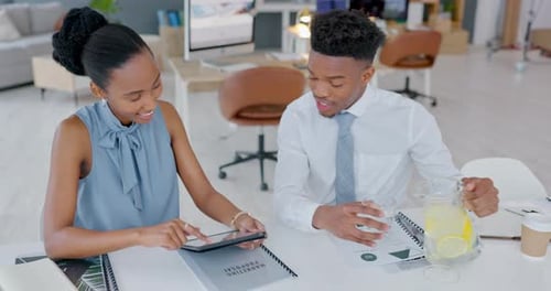 Coworkers Working Together at Desk With Tablet