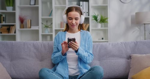 Woman Enjoys Music on Phone with Headphones