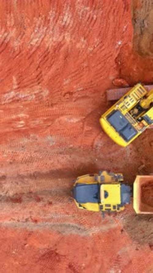 Construction Site with Excavator and Dump Truck Aerial View