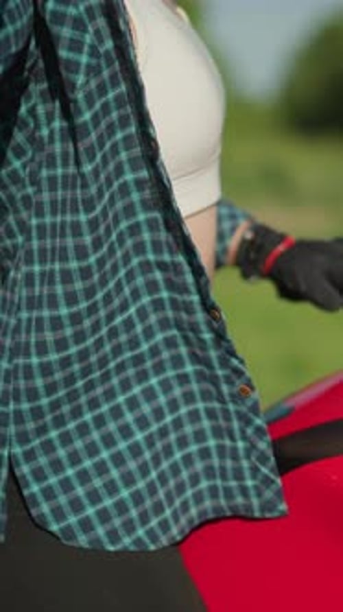 Woman Putting on Motorcycle Helmet Outdoors