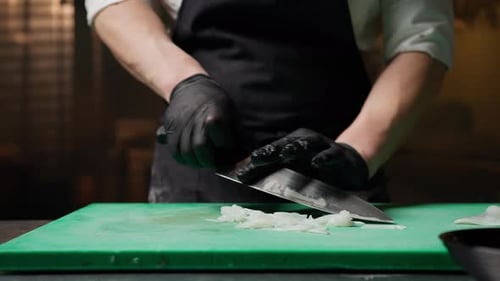 Chef Slicing Onions in a Restaurant Kitchen