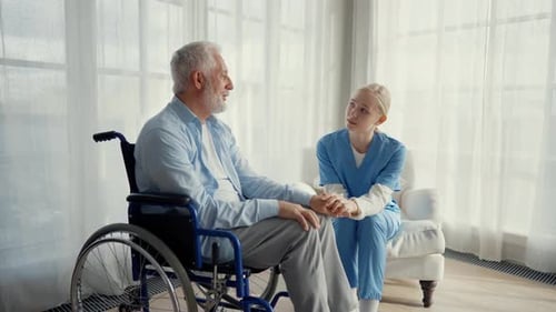 Elderly Man Talking With Caregiver in Bright Room