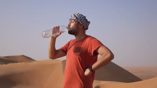 Young Man Drinking Water Standing on Desert, Super 240