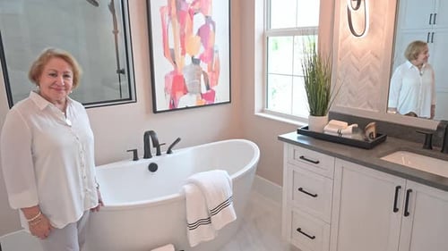 woman is pleased with beautiful new home bathroom and soaking tub installation