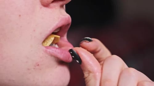 Young Woman Mouth Eating Potato Chips CloseUp in Slow Motion
