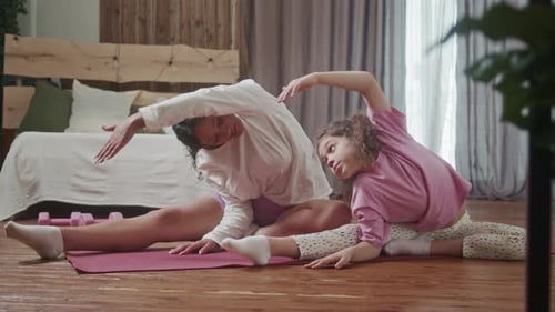 Woman and Girl Stretching on Yoga Mat at Home