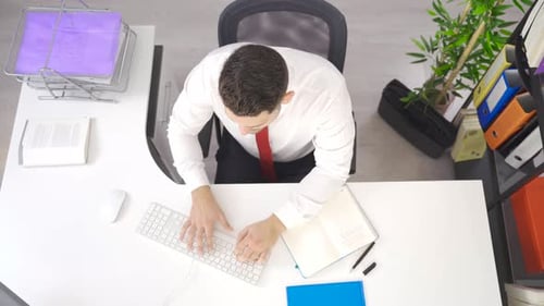 Businessman is using computer at his desk in the office.