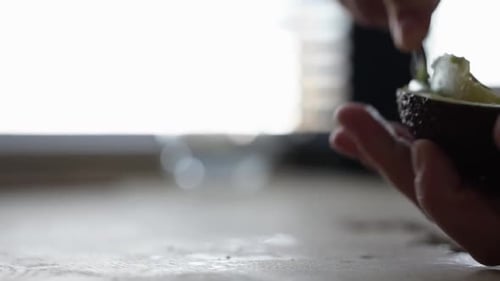 Preparing fresh avocado in the kitchen with spoon