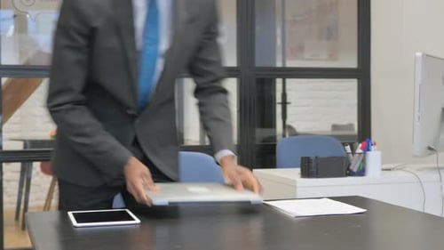 Businessman Arrives at Desk and Opens Laptop