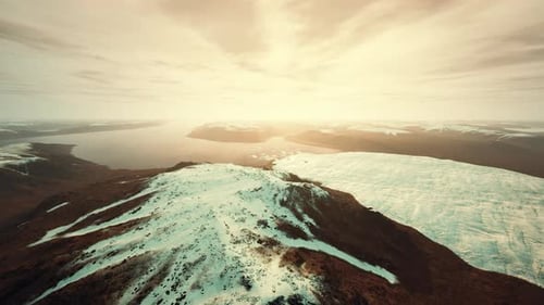 Aerial View Flying Over Snowy Mountains and Glacier Lake