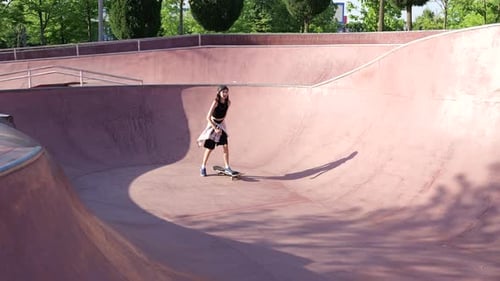 Teen Girl Skateboarding in Empty Urban Skatepark