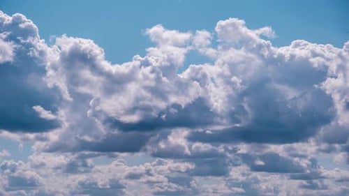 Fluffy White Clouds Moving Across Vibrant Blue Sky