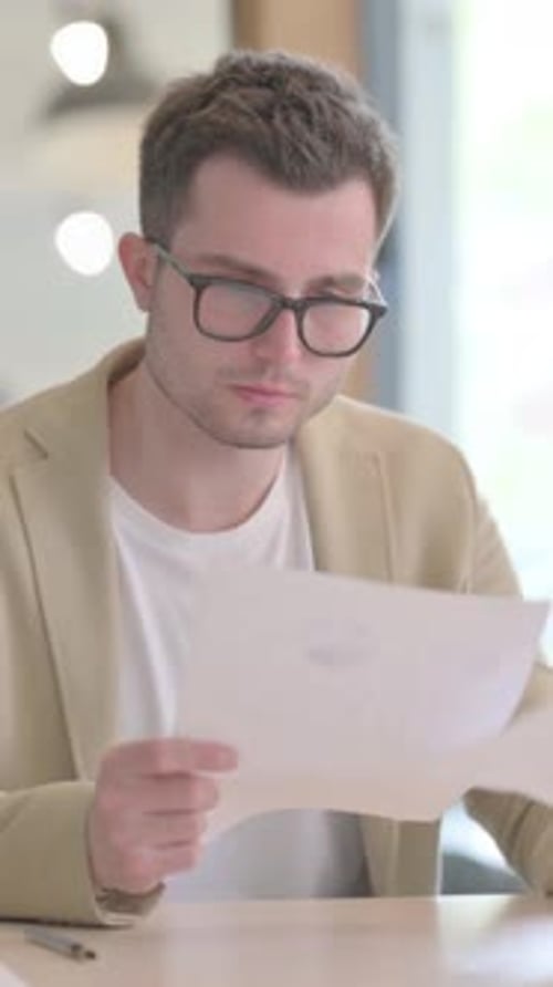 Excited Young Man Reads Good News on Paper