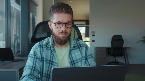 Office Employee Focusing Intently on Work at Laptop Professionalism and Dedication in Modern Office