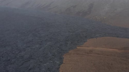 Foggy scenery in valley with dark black basalt rock from eruption