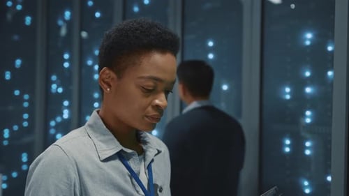 Young Smart IT Female Specialist Checking Software Working System Server Data in Data Center Storage