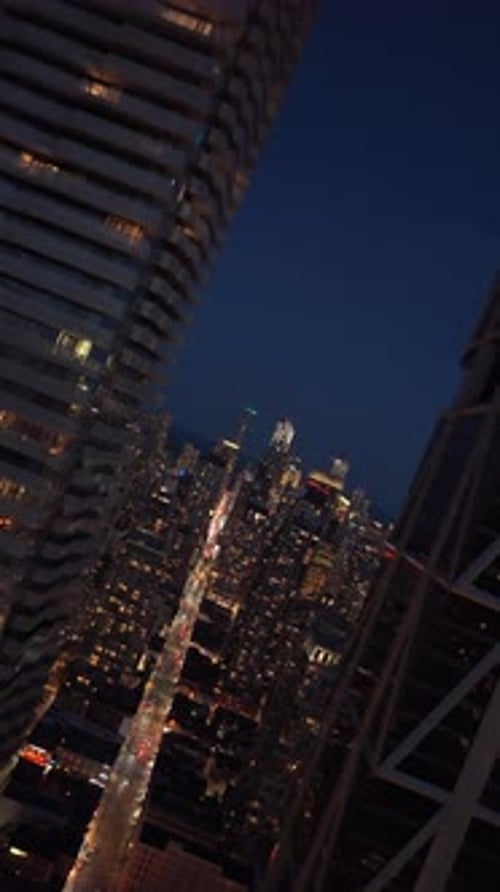 Dutch Angle Cinematic Flight Between Illuminated Skyscrapers and Apartment Buildings Over Yonge