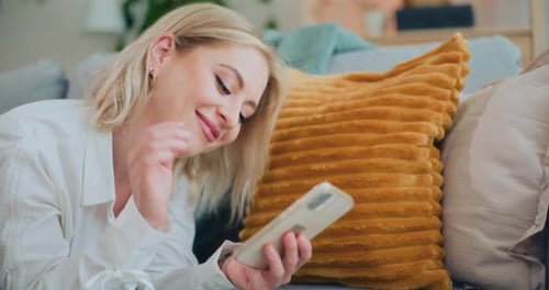 Woman Lies on Couch Using Cell Phone