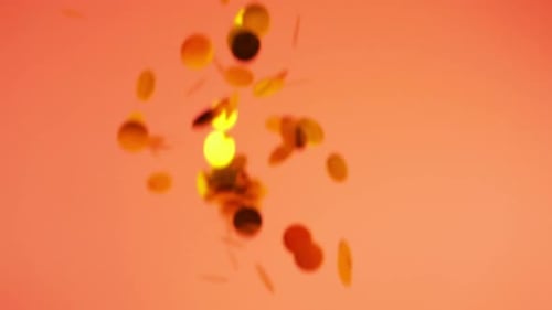 Gold Confetti Falling on an Orange Background