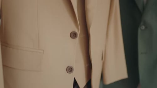 Close up of beige suit jacket buttons and fabric details