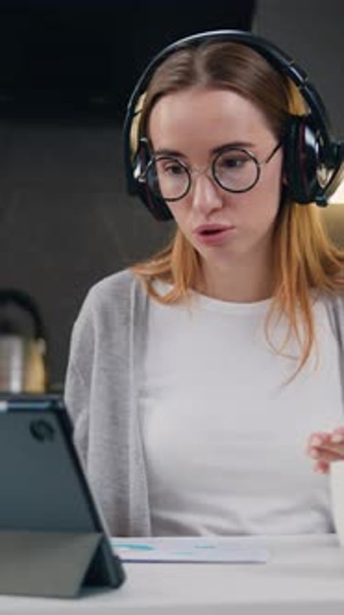 Belle femme indépendante parlant lors d'une vidéoconférence en ligne avec un microphone et un casque