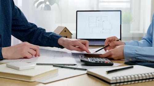 Architects Reviewing Construction Blueprints in Office