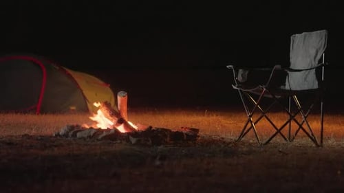 Campfire Burns Brightly at Campsite at Night