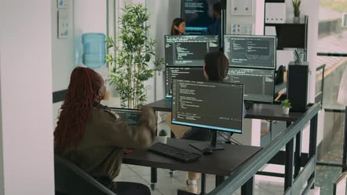 Une équipe diversifiée de programmeurs Ai Cloud parle de coder un script devant un ordinateur