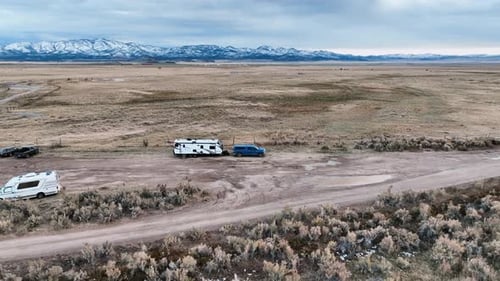 Motorhome Trailers Over Remote Plains Camping Ground In Utah, United States. Aerial Pullback Shot. M