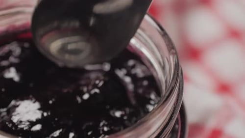Spoon Taking Fresh Homemade Jam from Jar