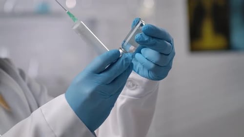 Doctor Filling Syringe with Vaccine in Hospital