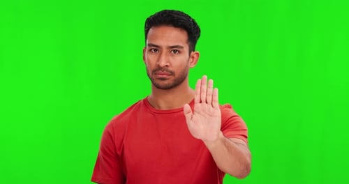 Green screen, hand and stop by man face in studio with no, reject or warning