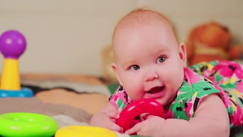 Smiling Infant Playing with Colorful Toys Indoors