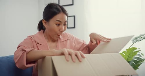 Woman Excitedly Opens a Delivery Box at Home