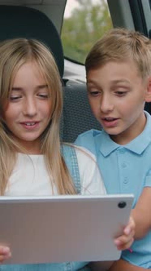 Children Sharing a Tablet Device Together in Car