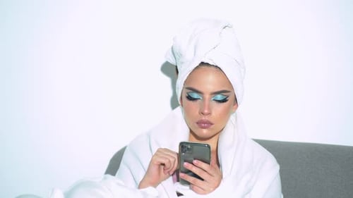 Woman Relaxing with Phone After Spa Treatment