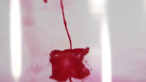 Red paint dissolving in water shot in slow motion with Sony a7iii.