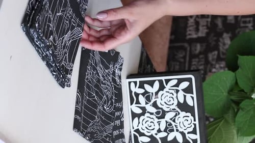 Woman Folds a Black and White Napkin