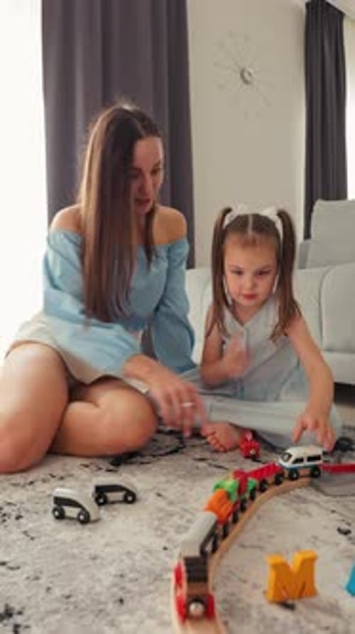 Mom and Daughter Playing With Toy Train at Home